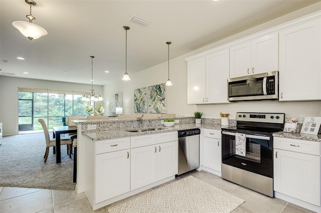 kitchen with stainless steel appliances, decorative light fixtures, and white cabinets