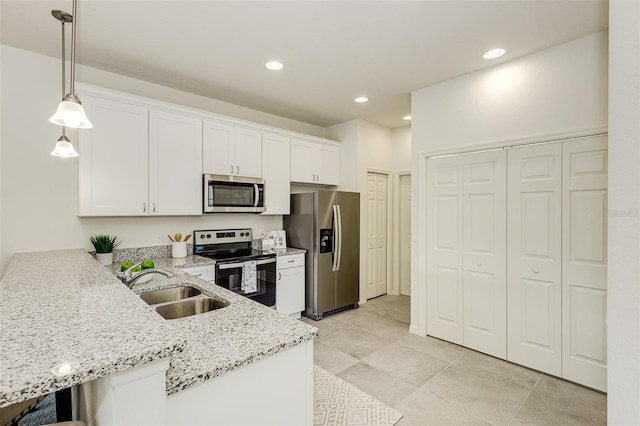 kitchen featuring stainless steel appliances, hanging light fixtures, white cabinetry, a sink, and a peninsula