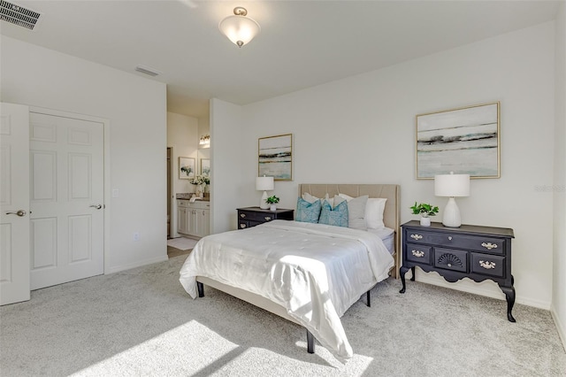 bedroom with light carpet, ensuite bathroom, visible vents, and baseboards