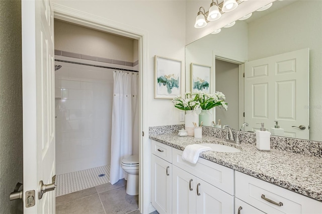 bathroom with a shower stall, vanity, toilet, and tile patterned floors