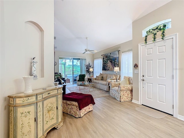 living room featuring ceiling fan, baseboards, and wood finished floors