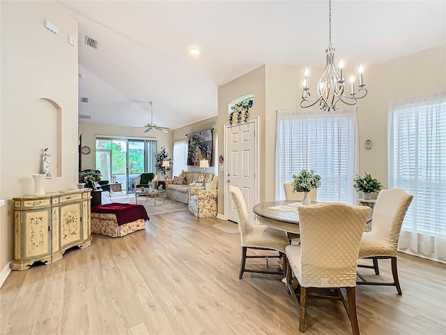 dining area featuring lofted ceiling, visible vents, light wood finished floors, and ceiling fan with notable chandelier