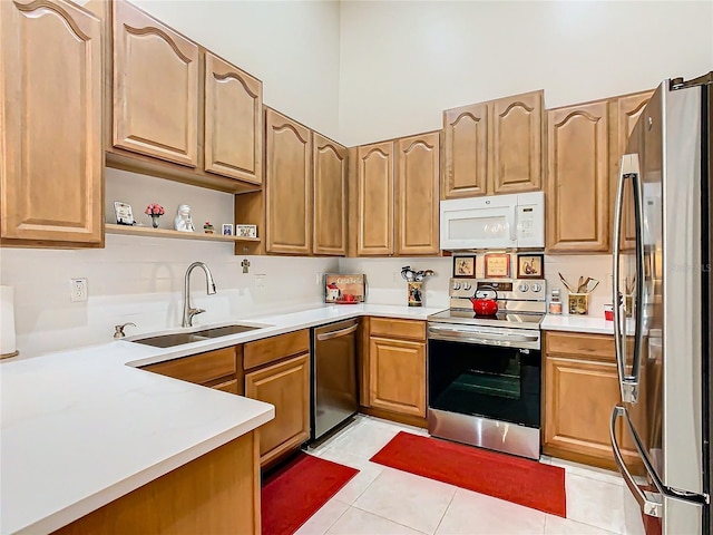 kitchen with a sink, light countertops, appliances with stainless steel finishes, brown cabinets, and open shelves