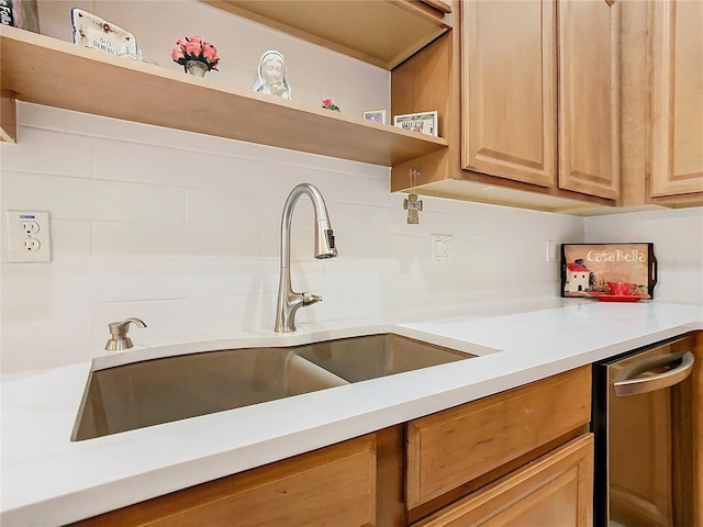 kitchen with open shelves, stainless steel dishwasher, light countertops, and a sink