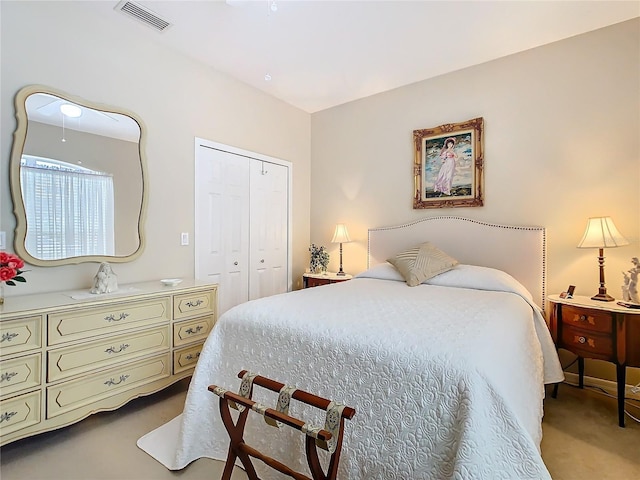 bedroom with a closet, visible vents, and light carpet