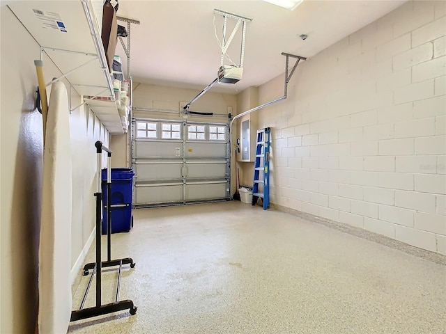 garage with concrete block wall and a garage door opener