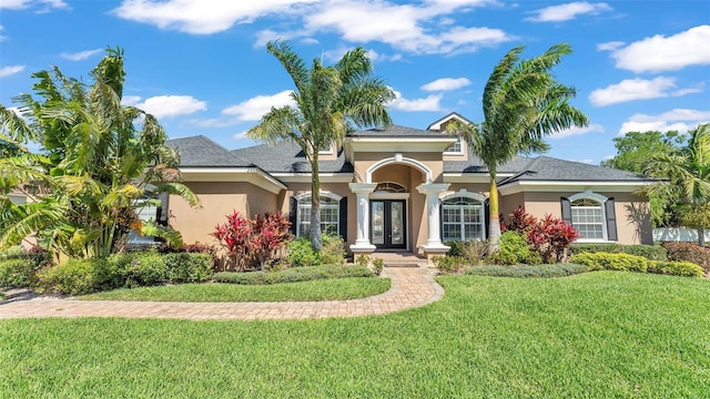 view of front of house with a front lawn, french doors, and stucco siding