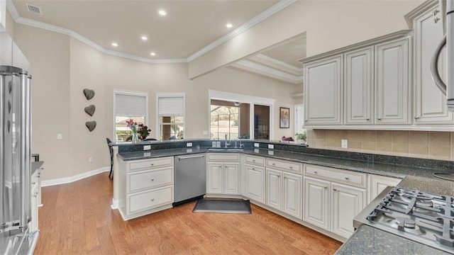 kitchen featuring visible vents, dishwasher, ornamental molding, a peninsula, and light wood-type flooring