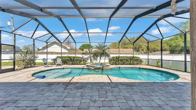 view of pool with a pool with connected hot tub, a lanai, a patio, and fence