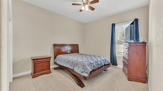 bedroom with multiple windows, ceiling fan, light carpet, and baseboards