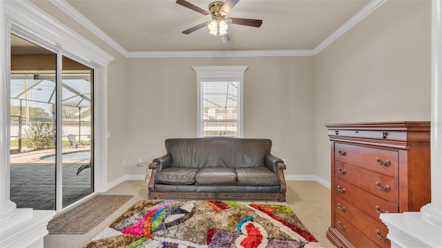 sitting room with ornamental molding, carpet flooring, baseboards, and a ceiling fan