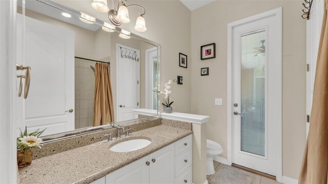 bathroom featuring toilet, curtained shower, tile patterned flooring, and vanity