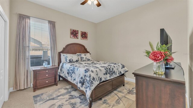 bedroom with ceiling fan, baseboards, and light colored carpet