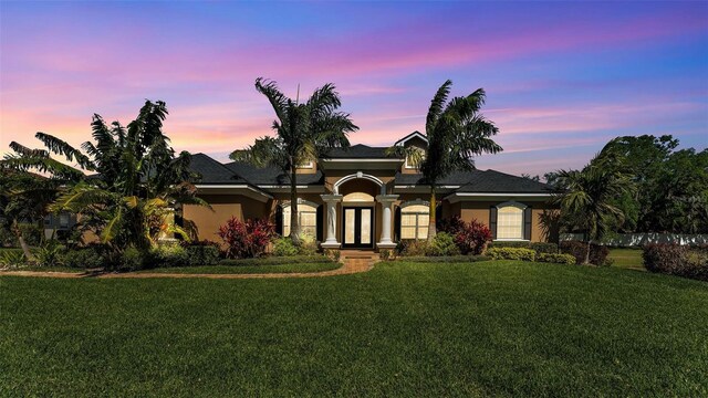 view of front of house with a lawn and stucco siding