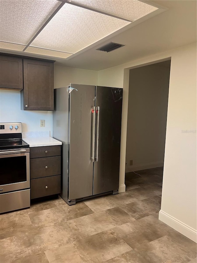 kitchen featuring appliances with stainless steel finishes, light countertops, visible vents, and dark brown cabinets