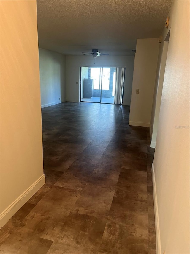 spare room featuring ceiling fan, a textured ceiling, and baseboards