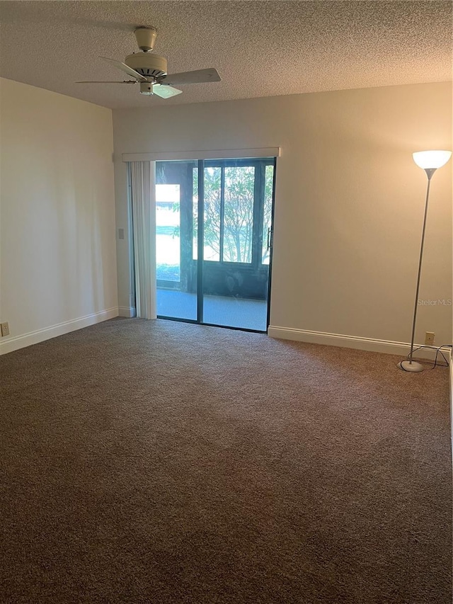 carpeted empty room with a ceiling fan, baseboards, and a textured ceiling