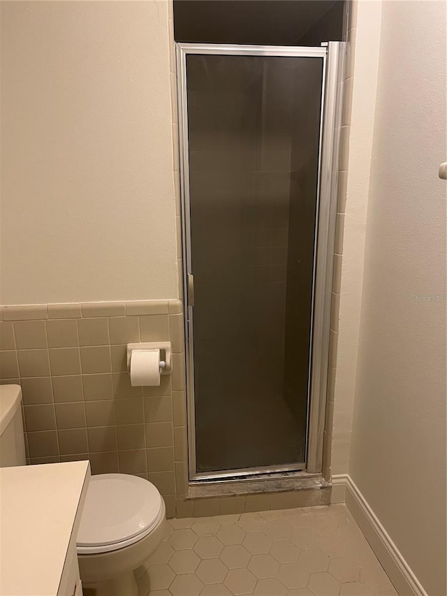 full bath with tile patterned flooring, toilet, vanity, tile walls, and a stall shower