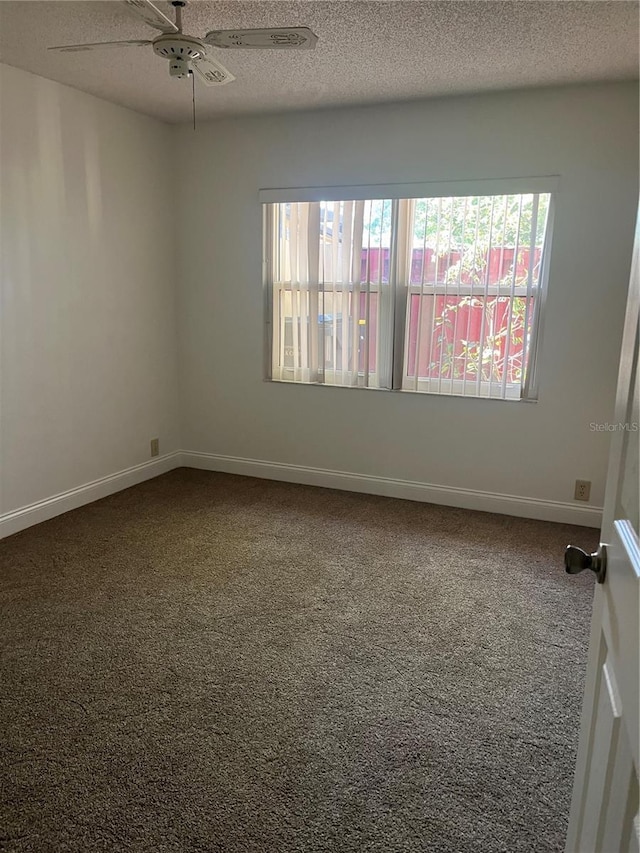 unfurnished room featuring a textured ceiling, carpet, a ceiling fan, and baseboards