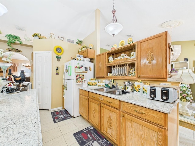 kitchen featuring arched walkways, visible vents, freestanding refrigerator, light tile patterned flooring, and a sink