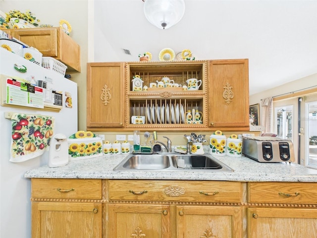 kitchen with visible vents, a sink, and freestanding refrigerator