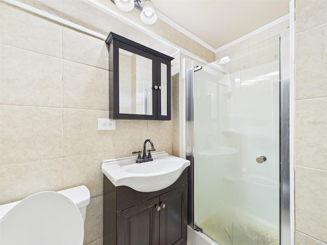 bathroom featuring toilet, vanity, tile walls, ornamental molding, and a stall shower