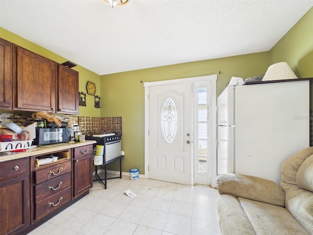 entryway featuring light tile patterned flooring and a textured ceiling