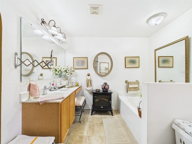 full bath featuring a garden tub, tile patterned floors, visible vents, and vanity