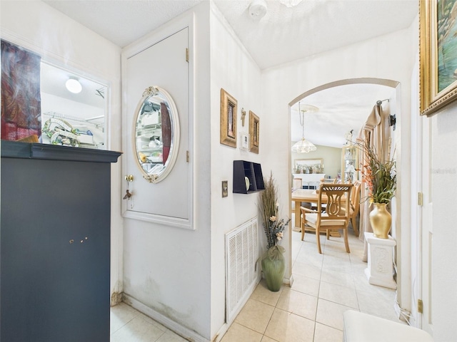 entryway with light tile patterned floors, visible vents, and arched walkways