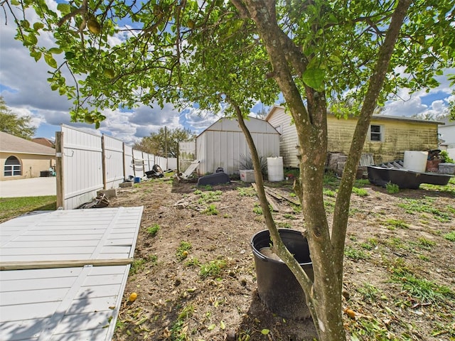 view of yard featuring an outdoor structure, fence, and a shed