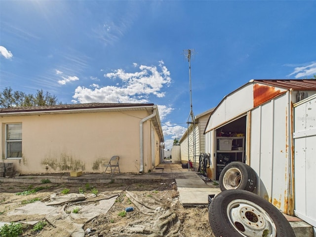 view of home's exterior with an outdoor structure and stucco siding