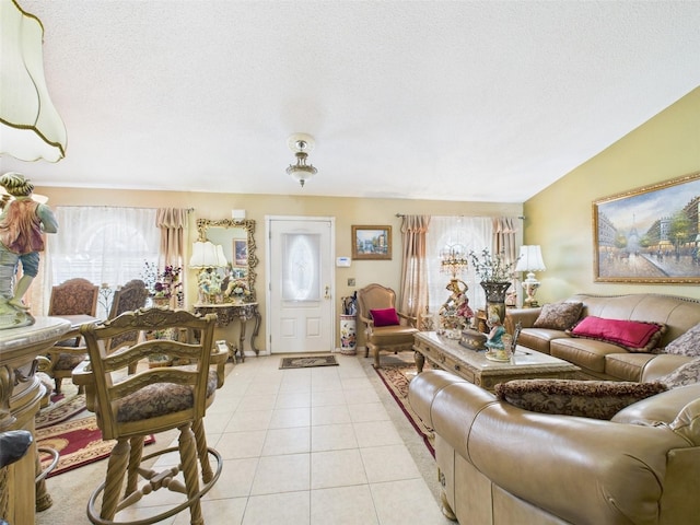 living area featuring vaulted ceiling, a textured ceiling, and light tile patterned floors