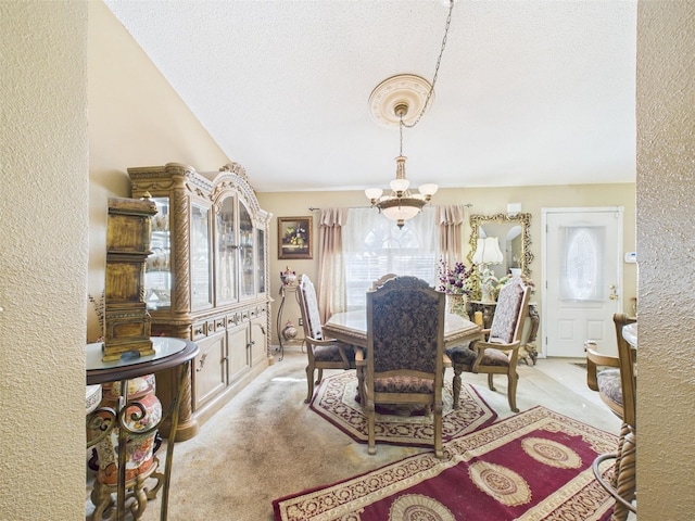 dining area with light carpet, a textured wall, a textured ceiling, and an inviting chandelier