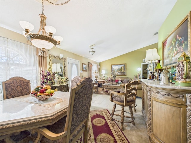 dining area with lofted ceiling, light tile patterned floors, and a notable chandelier