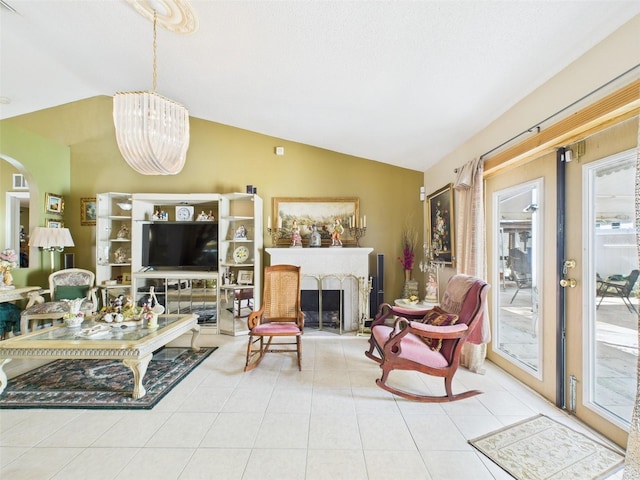 living area with lofted ceiling, a fireplace with raised hearth, visible vents, and tile patterned floors