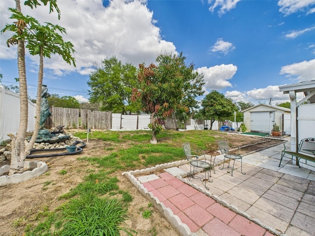 view of yard featuring a fenced backyard, a patio, an outdoor structure, and a storage unit