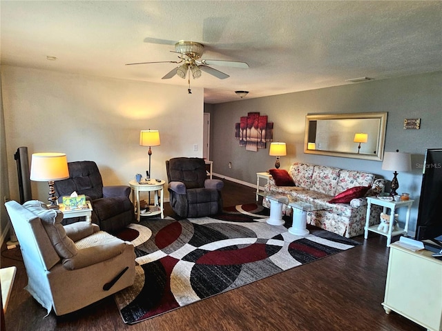 living area with visible vents, a ceiling fan, a textured ceiling, wood finished floors, and baseboards