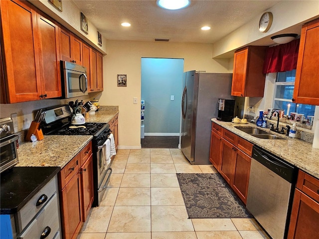 kitchen with light tile patterned floors, visible vents, appliances with stainless steel finishes, a sink, and a textured ceiling