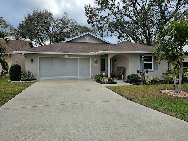 ranch-style home with stucco siding, a shingled roof, an attached garage, driveway, and a front lawn