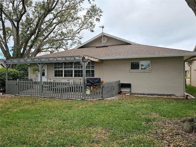 rear view of property with a patio area, a lawn, fence, and stucco siding