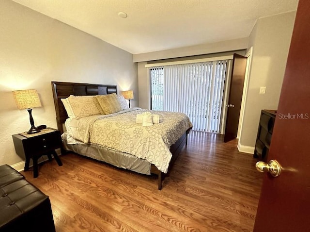 bedroom with wood finished floors and baseboards