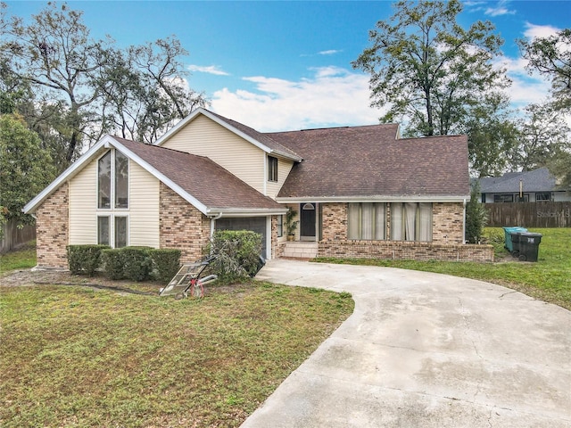 view of front of property with brick siding, a shingled roof, fence, driveway, and a front lawn