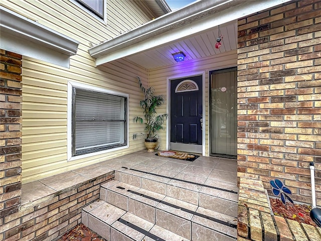 doorway to property featuring brick siding