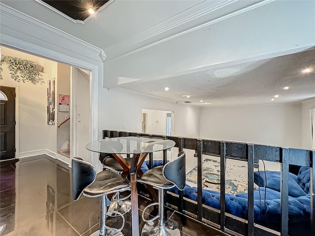 dining space featuring a textured ceiling, recessed lighting, baseboards, ornamental molding, and tile patterned floors