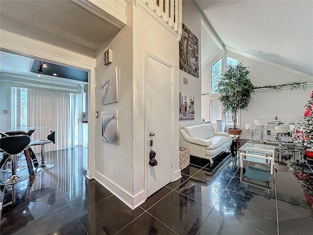 bathroom with high vaulted ceiling, plenty of natural light, and baseboards