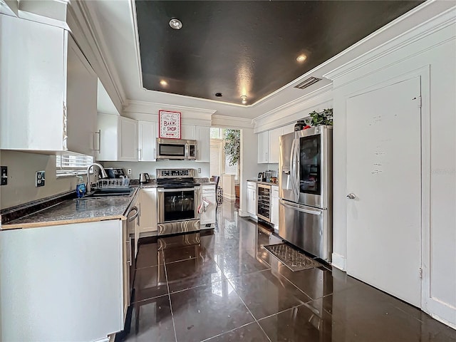 kitchen featuring crown molding, a raised ceiling, visible vents, appliances with stainless steel finishes, and a sink