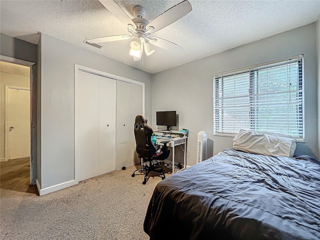 bedroom with carpet floors, a closet, ceiling fan, and a textured ceiling