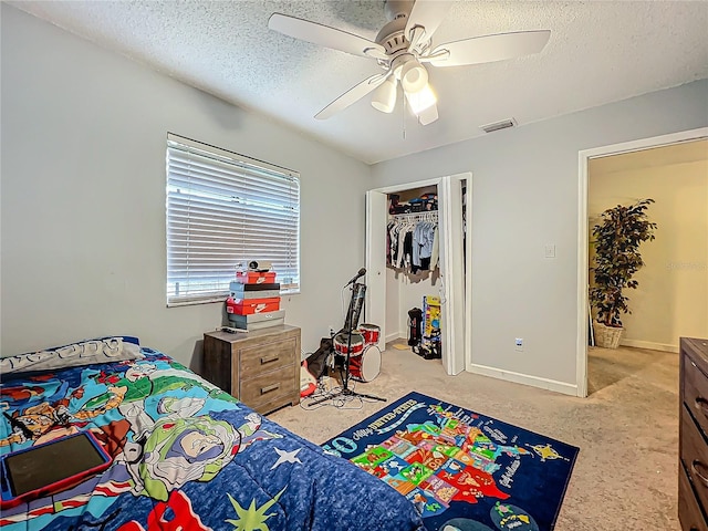 bedroom featuring baseboards, visible vents, ceiling fan, a textured ceiling, and a closet