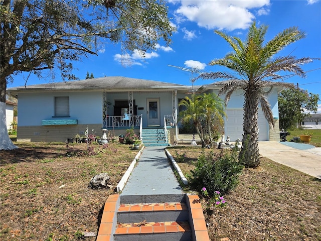 ranch-style house featuring a garage, covered porch, and driveway