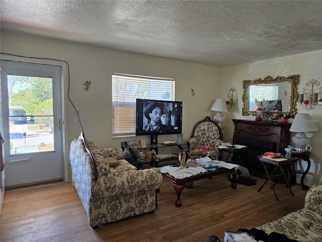 living room featuring a healthy amount of sunlight, a textured ceiling, and wood finished floors